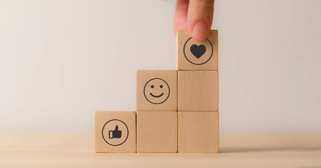 wood blocks with image of a thumbs up, smiley face and heart