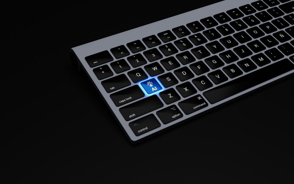 A partial view of a laptop keyboard with a single key illuminated in blue. The key features a robot hand icon and the letters "AI," suggesting artificial intelligence. The rest of the keys are black on a dark background.