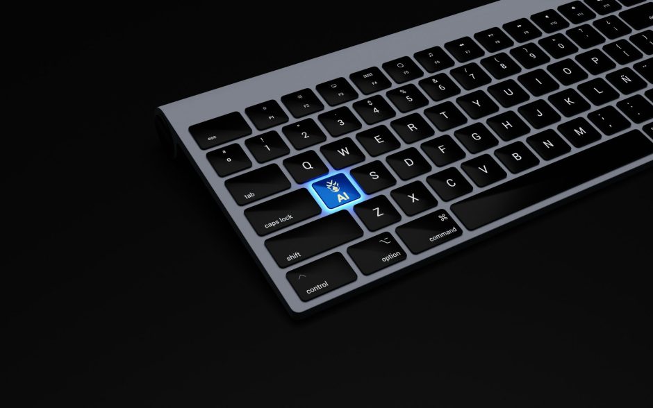 A partial view of a laptop keyboard with a single key illuminated in blue. The key features a robot hand icon and the letters "AI," suggesting artificial intelligence. The rest of the keys are black on a dark background.
