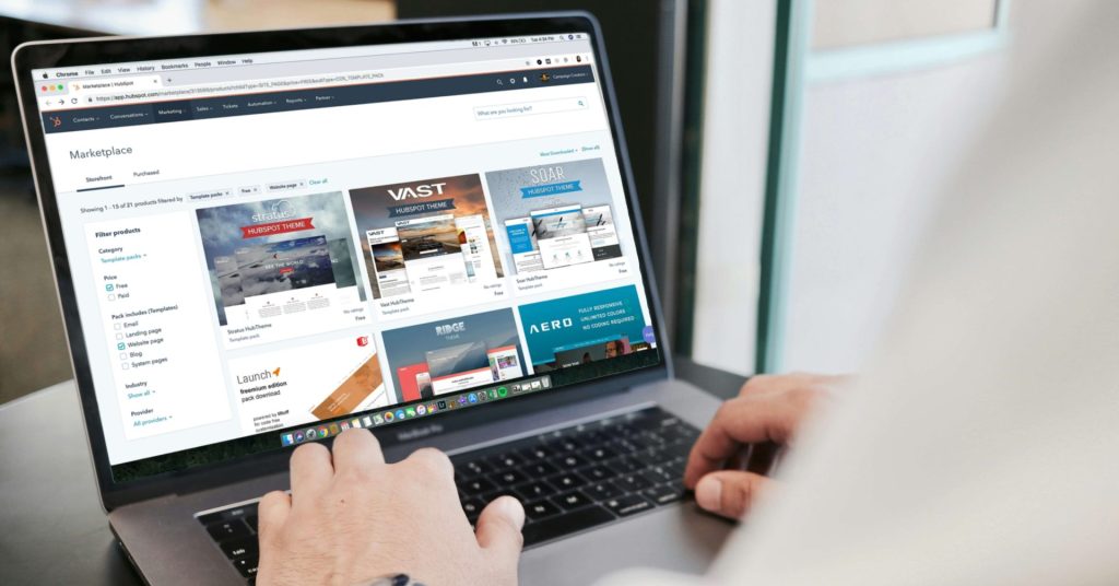 Person browsing a digital marketplace for website themes on a laptop computer.
